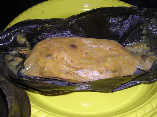 A conkie unwrapped from its banana leaf, showing the golden sweet cornmeal inside