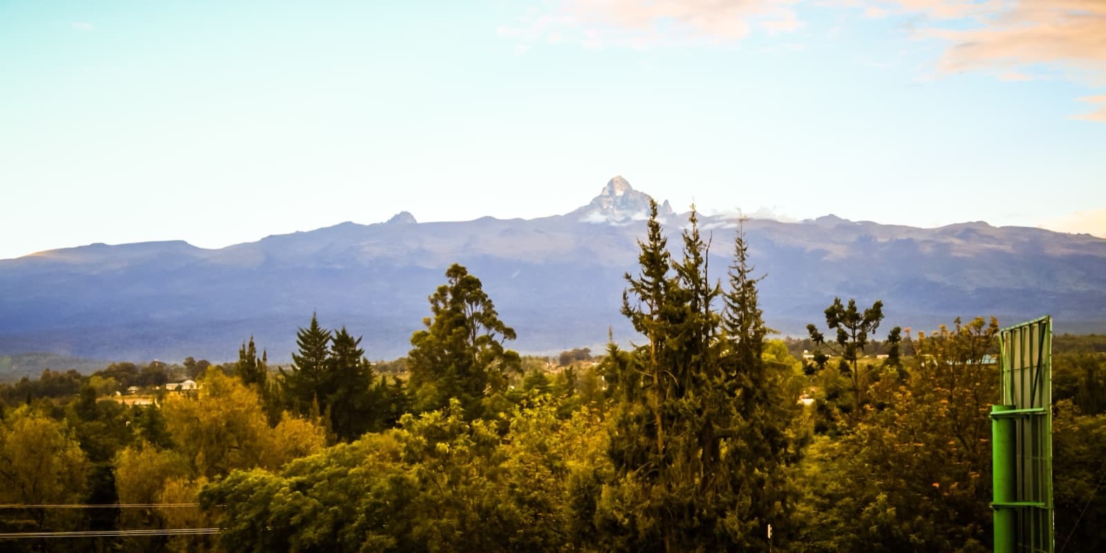 The jagged peaks of Mount Kenya rising above forest