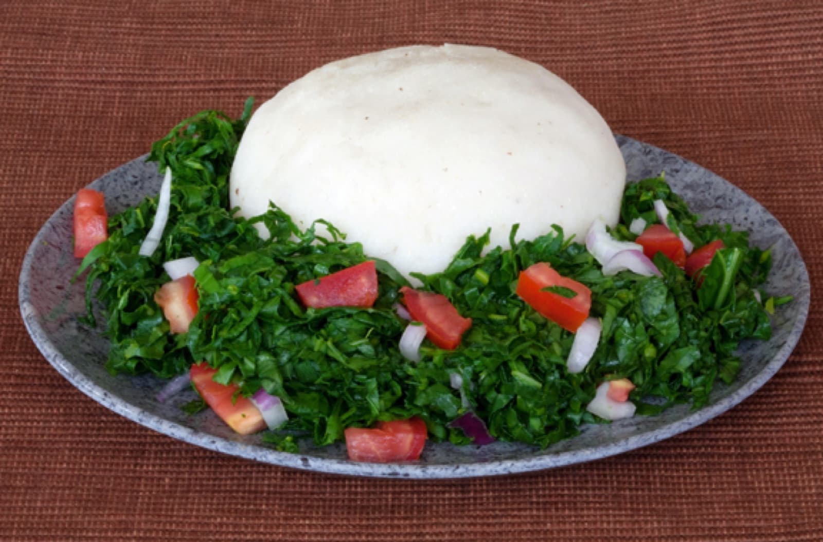 A plate of ugali served with sukuma wiki