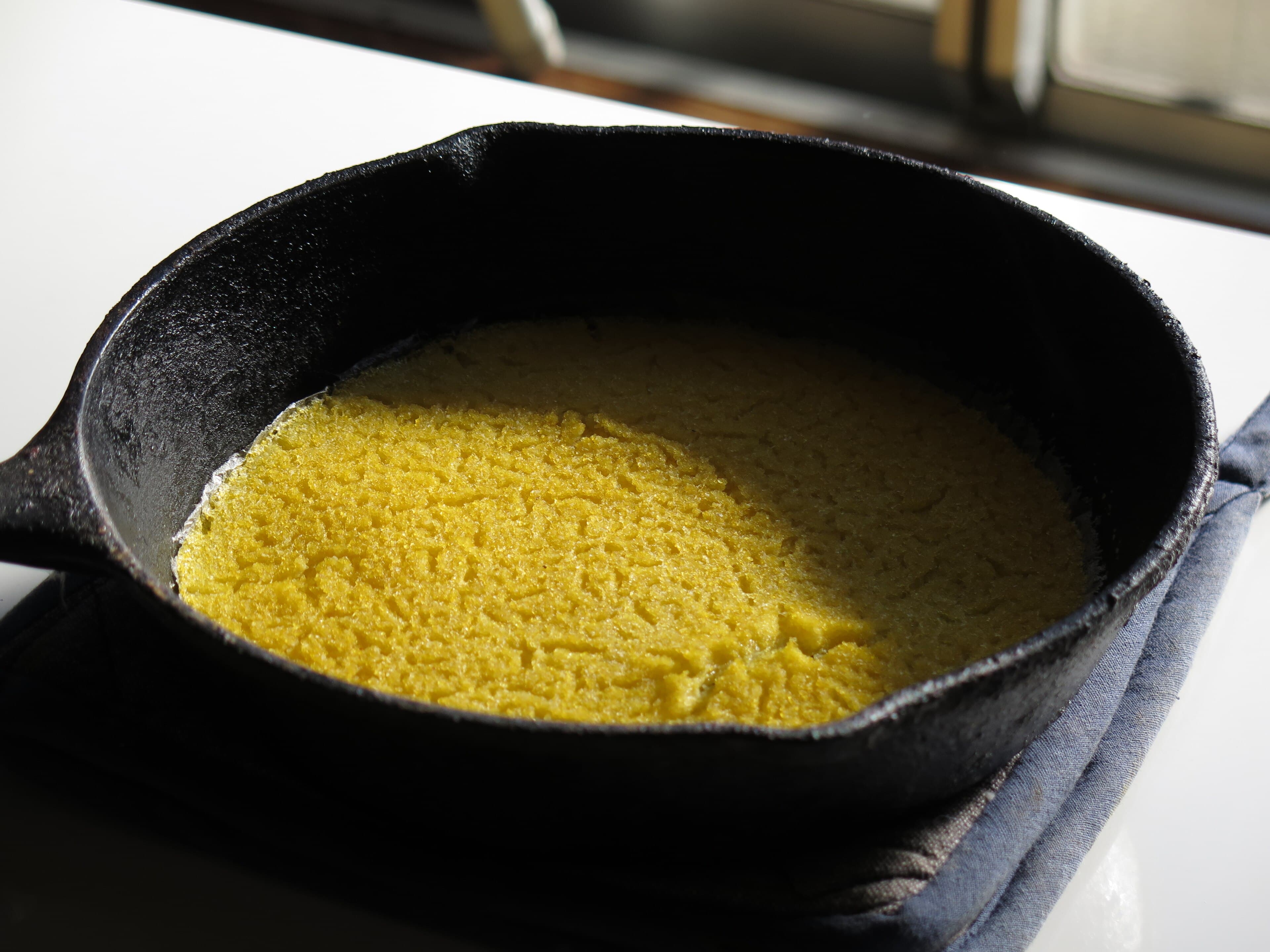 Golden rounds of johnnycake bread on a wooden board
